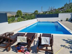 een kind in stoelen naast een zwembad bij Bazen na dan Saray pool in Mostar