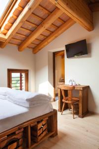 sypialnia z łóżkiem i drewnianym biurkiem w obiekcie Ca' Piadera Wine Relais w mieście Tarzo