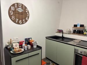 a kitchen with a clock hanging on the wall at Domus Anfiteatro Home Sweet Home Viterbo in Sutri