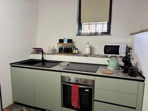 a kitchen with a stove top oven and a microwave at Domus Anfiteatro Home Sweet Home Viterbo in Sutri