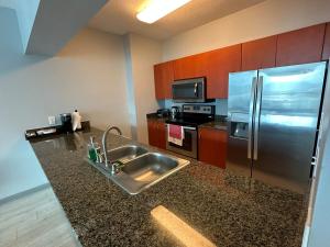 a kitchen with a sink and a stainless steel refrigerator at Stunning view from 42nd floor, Brickell-Miami financial district free self-parking spot, sleeps 4 in Miami +27 photos