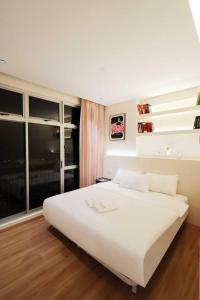 a white bed in a room with a large window at Midas Seri Alam Luxury Dopamine Jacuzzi in Masai