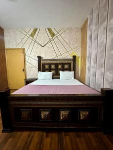 a bedroom with a large bed with purple sheets at Eden Plus Hotel-Garden Town in Lahore