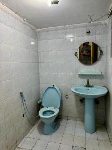 a bathroom with a blue toilet and a sink at Eden Plus Hotel-Garden Town in Lahore +28 photos