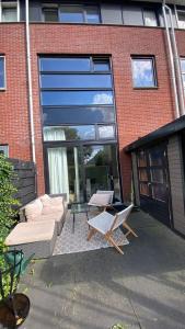 a patio with a couch and chairs in front of a building at Canal Garden Apartment StayWell Amsterdam in Amsterdam +43 photos