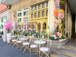 a group of tables and chairs in front of a window at Altstadt Living Würzburg in Würzburg