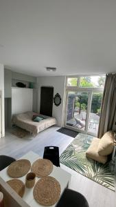 a living room with a bed and a table at Canal Garden Apartment StayWell Amsterdam in Amsterdam