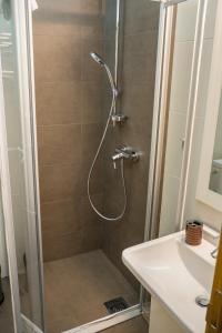 prysznic ze szklanymi drzwiami obok umywalki w obiekcie Apartments Belmont Becici w Budvie