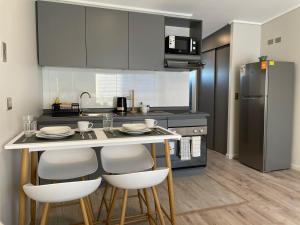 a kitchen with a table with chairs and a refrigerator at Condominio Palena in Puerto Montt