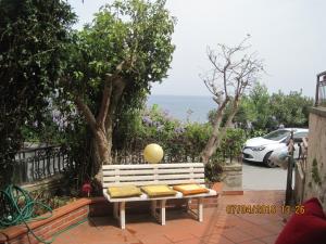 - un banc blanc installé sur une terrasse avec vue sur l'océan dans l'établissement Appartamento Mare, à Letojanni