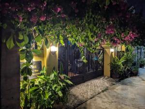 une clôture avec des fleurs dessus la nuit dans l'établissement Chez Xuan homestay & cookingclass, à Kon Rung (1)