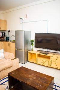 a living room with a large television and a couch at Myla homes in Kiambu