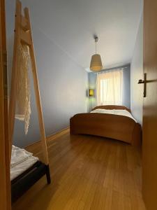 普里什蒂纳Artist's Apartment in Prishtina的一间卧室设有一张床、梯子和窗户