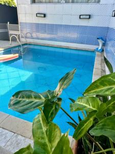 einem Pool mit einer Anlage vor einem Gebäude in der Unterkunft CASA PISCINA CHURRASQUEIRA Wi-Fi BERTIOGA in Bertioga