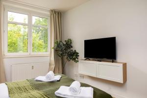a bedroom with a tv and a bed with towels at NORA Dresden Messe in Dresden