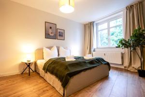 a bedroom with a bed and a large window at NORA Dresden Messe in Dresden