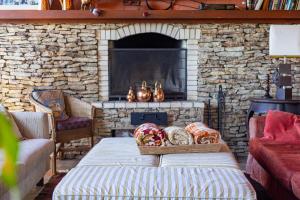 a living room with a stone fireplace with a couch at Pousada Benevento in Campos do Jordão