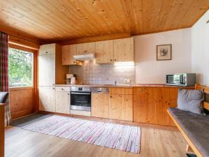 a kitchen with wooden cabinets and a wooden ceiling at Am Bauernhof Top 1 in Alpbach