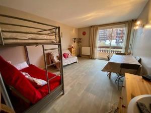 a room with a bunk bed and a table and a desk at appartement super devoluy in Le Dévoluy
