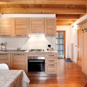 a kitchen with wooden cabinets and a stove top oven at Chalet Dolomiti Trentino in Sant’Orsola