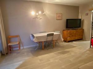 a room with a table and a tv and a table and chairs at appartement super devoluy in Le Dévoluy
