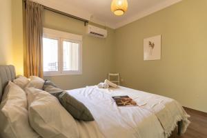 a bedroom with a large white bed with a window at Boho style 2BD in Thessaloniki