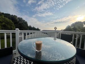 a cup of coffee sitting on a glass table on a balcony at Kieras View At Bideford Bay in Bideford