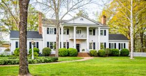 格伦艾伦Virginia Cliffe Inn的一座有门廊和院子的白色房子