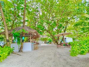 a group of tables and umbrellas on a beach at YUVi Blue Guesthouse at Himmafushi in Himmafushi