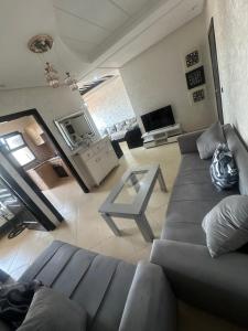 una sala de estar con un sofá y una mesa en Oumhani5, en Sale