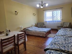 a bedroom with two beds and a table and chairs at Willa Republika 