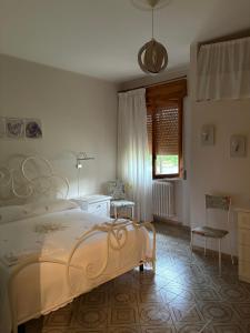 een slaapkamer met een bed, een stoel en een raam bij A casa di Rita in Toro