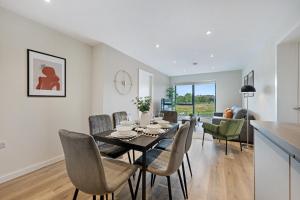 a dining room and living room with a table and chairs at Richmond Apartments - Air Host & Stay in Liverpool