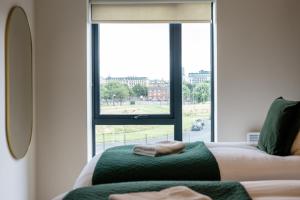 a living room with a large window and a couch at Richmond Apartments - Air Host & Stay in Liverpool