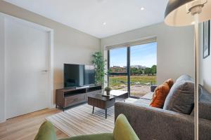 a living room with a couch and a flat screen tv at Richmond Apartments - Air Host & Stay in Liverpool