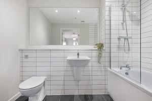 a bathroom with a toilet and a sink and a tub at Richmond Apartments - Air Host & Stay in Liverpool +56 photos
