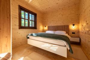 a bedroom in a log cabin with a bed at Forest Paradise in Ličko Petrovo Selo +46 photos
