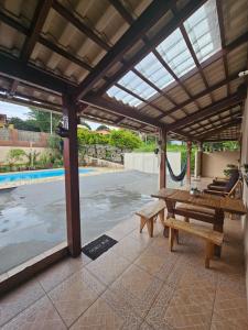 a patio with a wooden bench and a swing at Serradocipó-Casadorey in Serra do Cipo