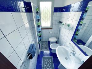 a blue and white bathroom with a sink and a toilet at Wohnung 1 Zwei Zimmer Wohnung In Cattolica Eraclea in Cattolica Eraclea +28 photos