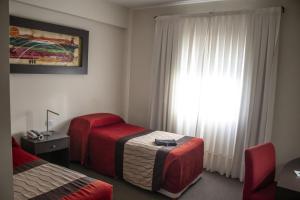 a hotel room with two beds and a window at Hotel Amucan in Neuquén
