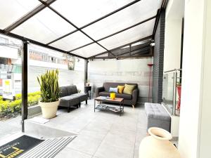 eine Terrasse mit Sofa, Stühlen und einem Tisch in der Unterkunft Terraza Hotel Bogota in Bogotá