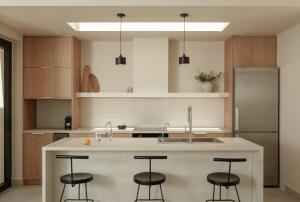 una cucina con bancone e 4 sgabelli di Noùs Corfu Villa a Kalámi