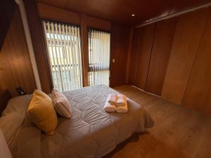 une chambre avec un lit avec deux pantoufles dessus dans l'établissement Departamento 3 ambientes, modernoso, cálido y a media cuadra de la calle principal. 2 PAX (V420), à San Martín de los Andes