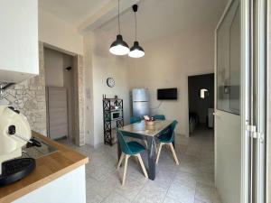 Una cocina y un comedor con mesa y sillas. en Dolce Casa Salentina, en San Pietro in Bevagna