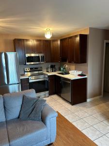 a kitchen with wooden cabinets and a blue couch at Lakeview Resort Motel in Wasaga Beach