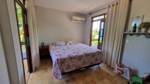 1 dormitorio con 1 cama con colcha rosa en Casa Lyrio - Itacimirim, en Camassari