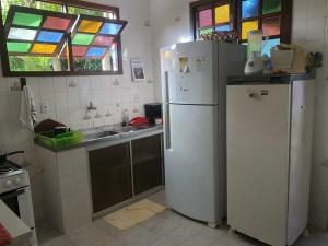 Una cocina con un refrigerador blanco y un fregadero. en Casa Lyrio - Itacimirim, en Camassari 19 fotos más