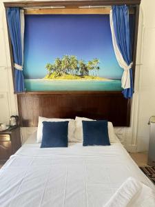 una camera da letto con un letto grande con un dipinto di una spiaggia di Acropole Alexandria Hotel ad Alessandria d'Egitto