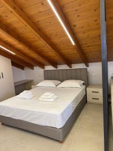 a bedroom with a large bed with wooden ceilings at Monemvasia View in Monemvasia