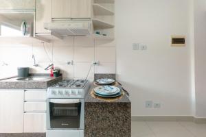 a kitchen with a stove and plates on a counter at Veja Este Apê Completo! - PS505 in Maringá